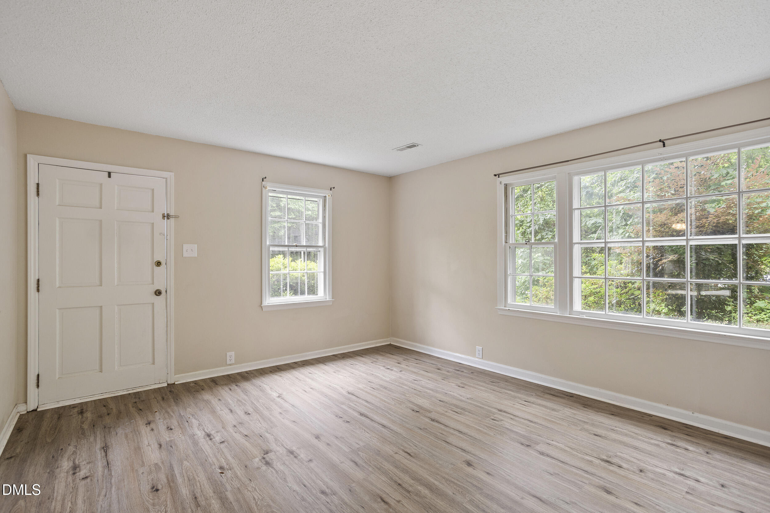 1801 Quail Ridge Road Raleigh, NC 27609 - Photo 7 of 29 a view of an empty room with wooden floor and a window