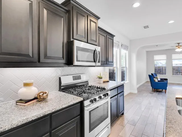 a kitchen with stainless steel appliances granite countertop a stove and a microwave