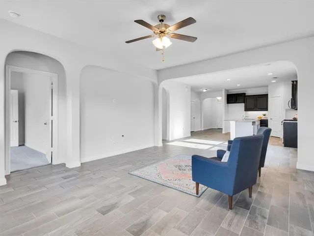 a living room with furniture and a view of kitchen