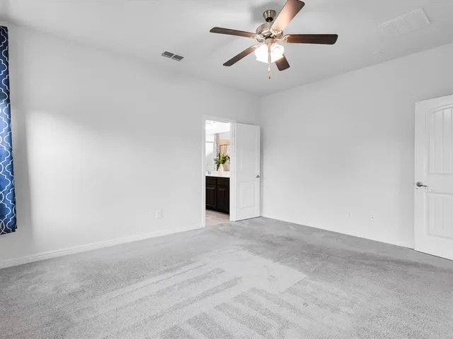 a view of a big room with a chandelier fan and windows