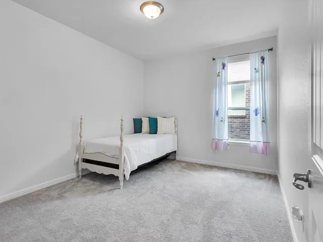 a white bed sitting in a room next to a window