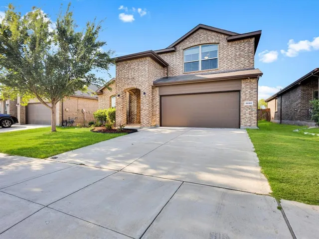 a front view of a house with yard and trees