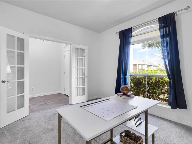 a view of a workspace with furniture and a window