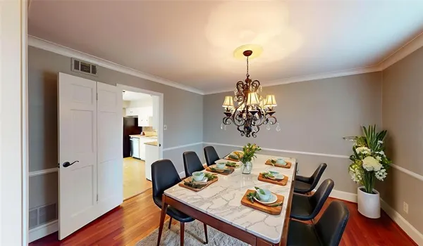 a view of a dining room with furniture wooden floor and chandelier