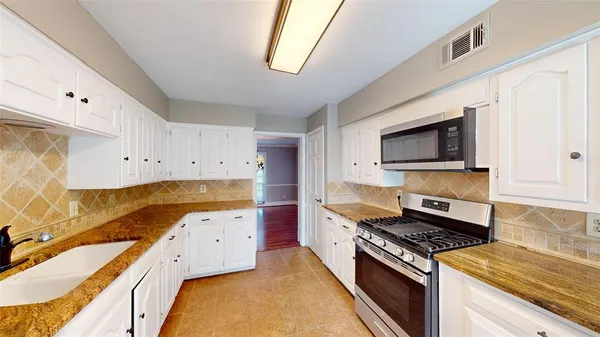 a kitchen with a stove a sink and a microwave