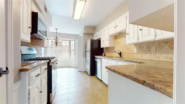 a kitchen with stainless steel appliances granite countertop a stove a sink and a refrigerator
