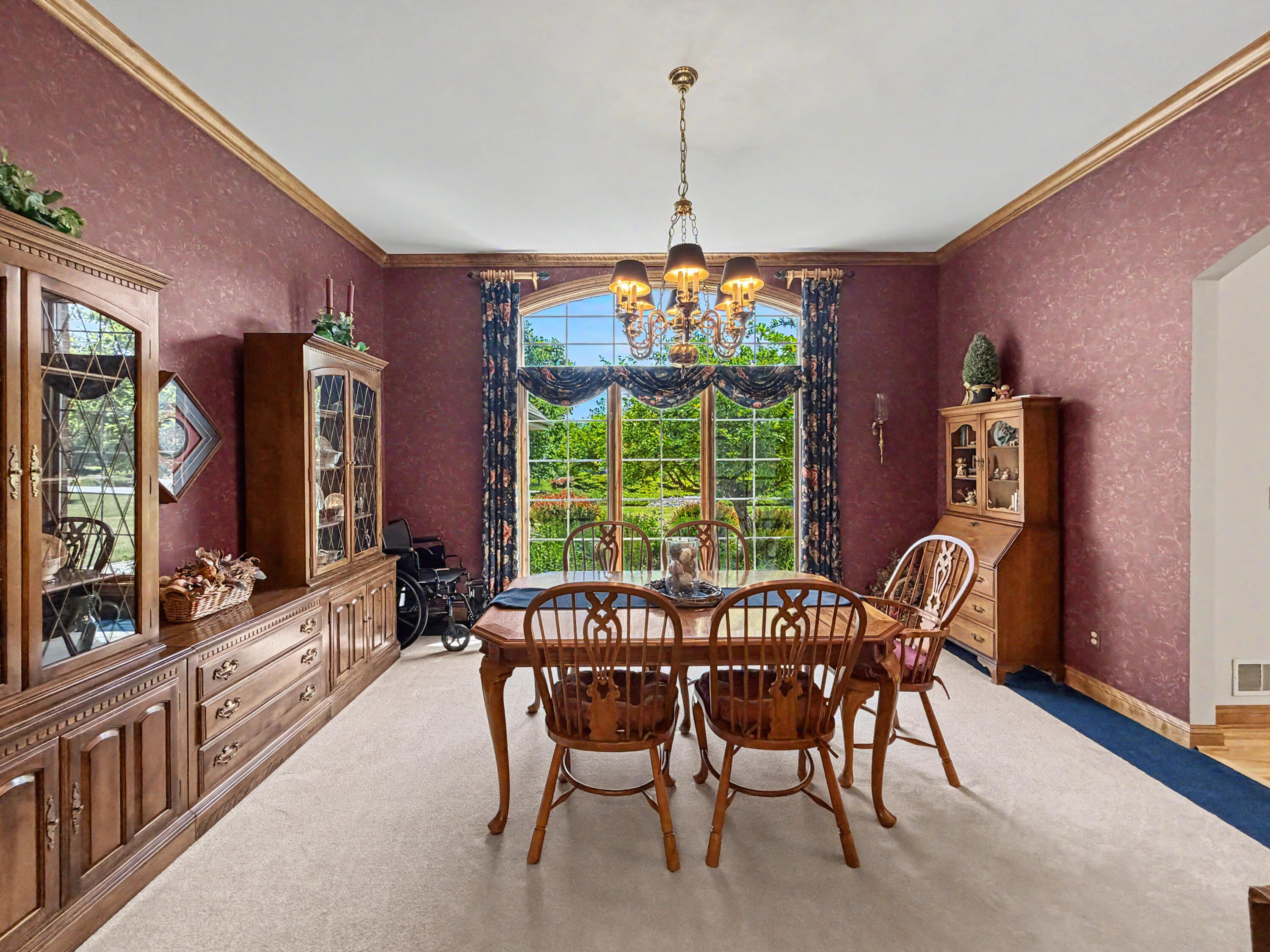 W291-s5245 Ridgefield Road Waukesha, WI 53189 - Photo 14 of 44 Spacious dining room with oversized arched window, elegant chandelier, rich wood trim, built in buffet and china cabinet and beautiful views of the landscaped front yard.