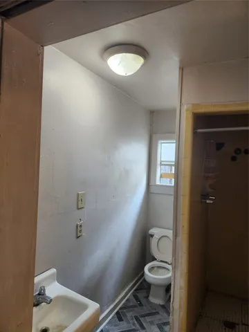 a bathroom with a toilet a sink and mirror