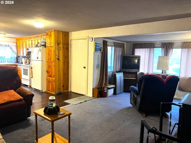 a living room with furniture a flat screen tv and large window
