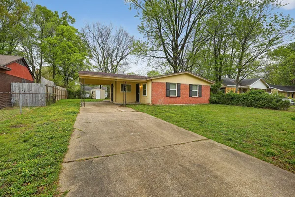 a front view of house with yard and green space