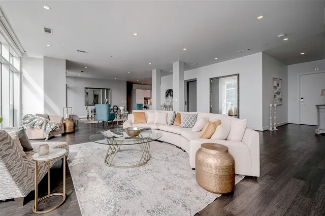 a living room with furniture a wooden floor and a chandelier