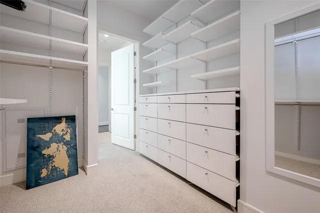 a view of walk in closet with clothes and shoes