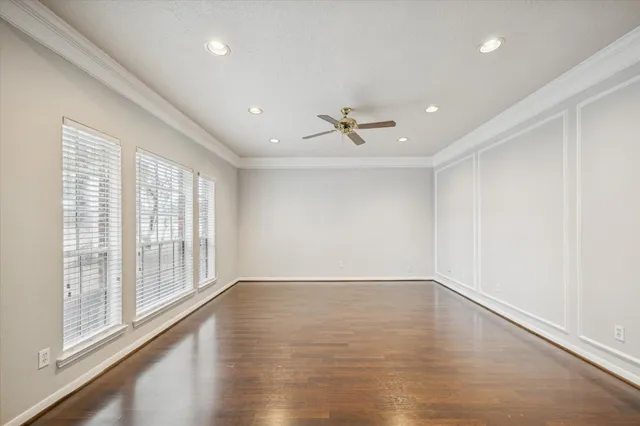a view of an empty room with a window and wooden floor