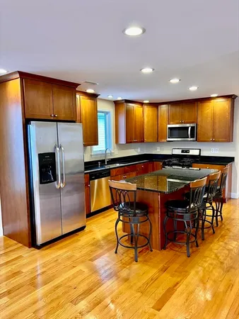 a kitchen with stainless steel appliances kitchen island granite countertop a table and chairs in it