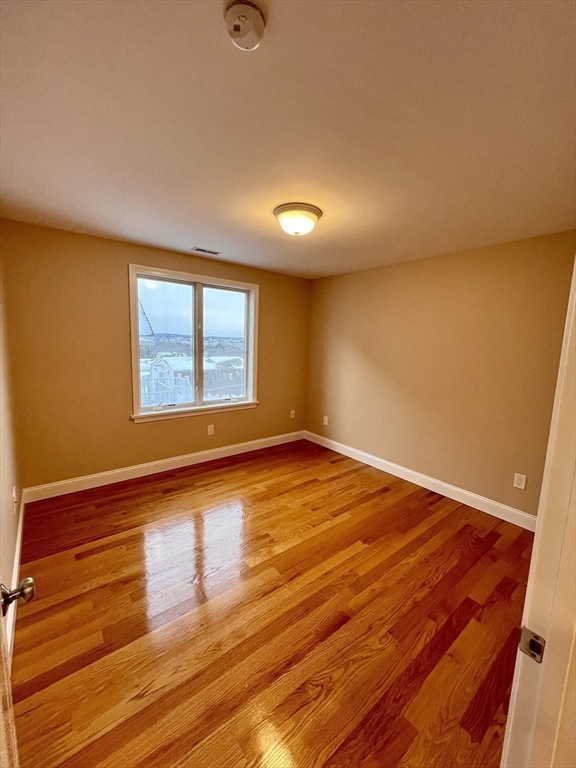 31 Rand Street, Unit 2 Revere, MA 02151 - Photo 6 of 15 an empty room with wooden floor and windows