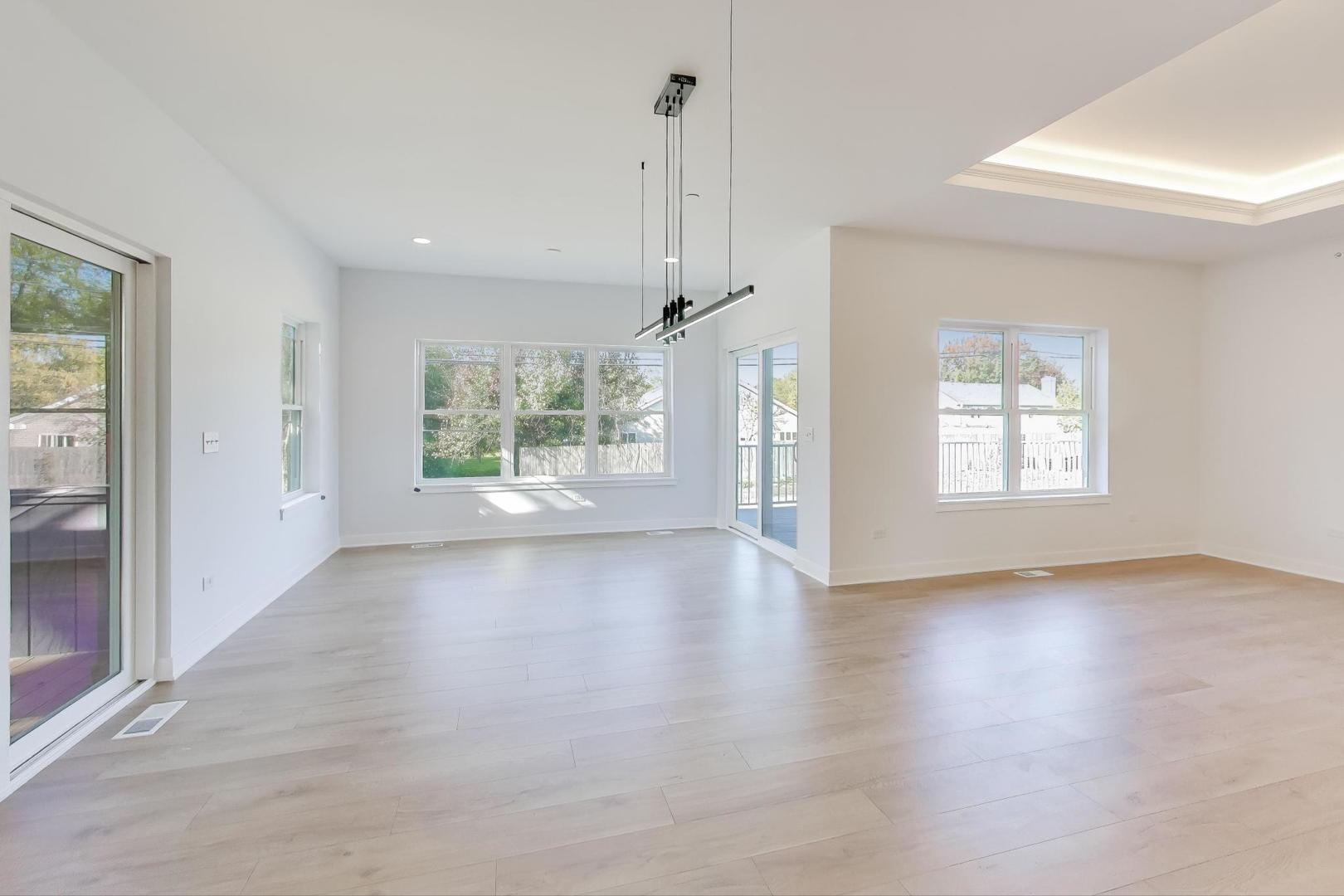 894 North Quentin Road Palatine, IL 60067 - Photo 8 of 29 a view of an empty room with a window and wooden floor