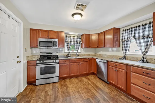 a kitchen with stainless steel appliances granite countertop a stove a sink dishwasher and a microwave oven with cabinets