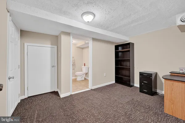 a view of an empty room with closet and a window