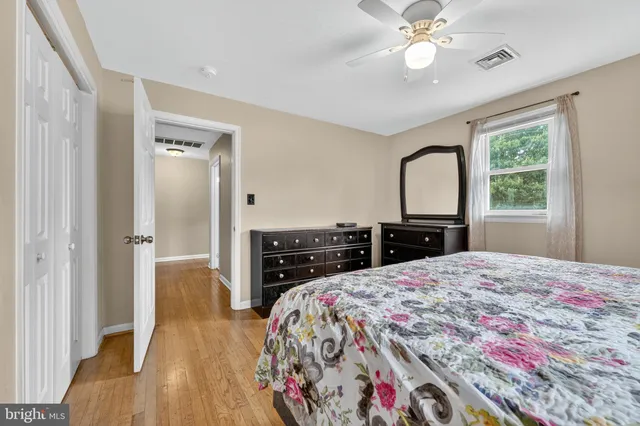 a bedroom with a bed and a dresser with mirror