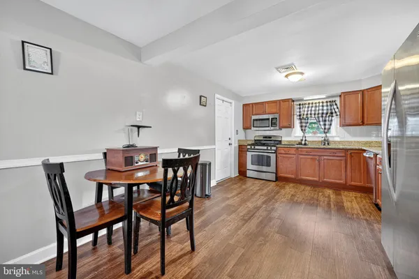 a kitchen with stainless steel appliances wooden floors and wooden cabinets