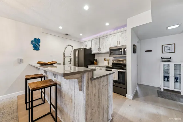 a kitchen with stainless steel appliances granite countertop a refrigerator and a stove top oven