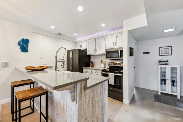 a kitchen with kitchen island a refrigerator stove and microwave