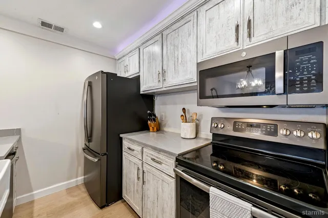 a kitchen with stainless steel appliances granite countertop a refrigerator stove and microwave