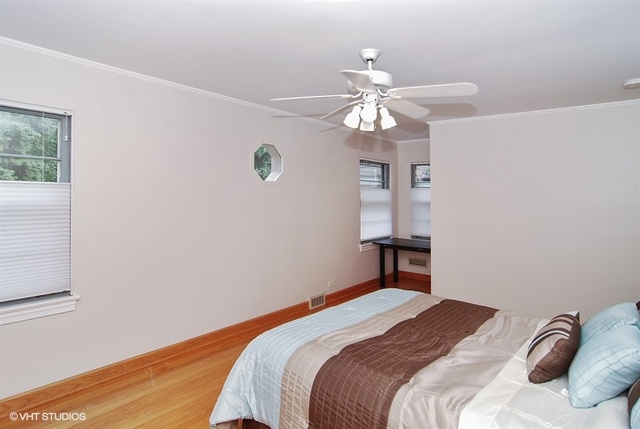 517 Berkeley Road Riverside, IL 60546 - Photo 9 of 15 a bedroom with a bed and a chandelier