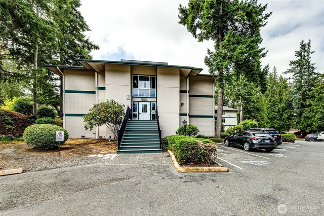 a front view of a building with street view and trees