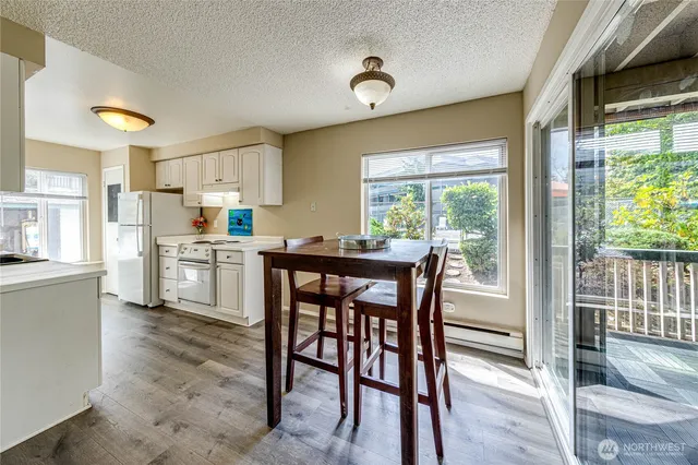 a open dining room with stainless steel appliances a table and chairs