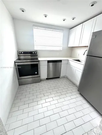 a kitchen with a stove a refrigerator and a sink