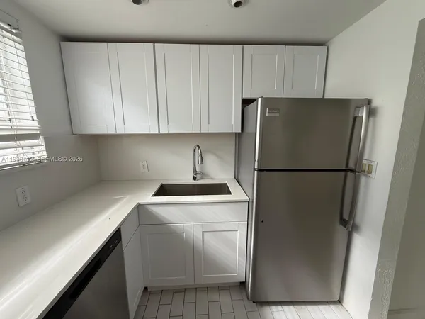 a kitchen with a refrigerator sink stove and cabinets