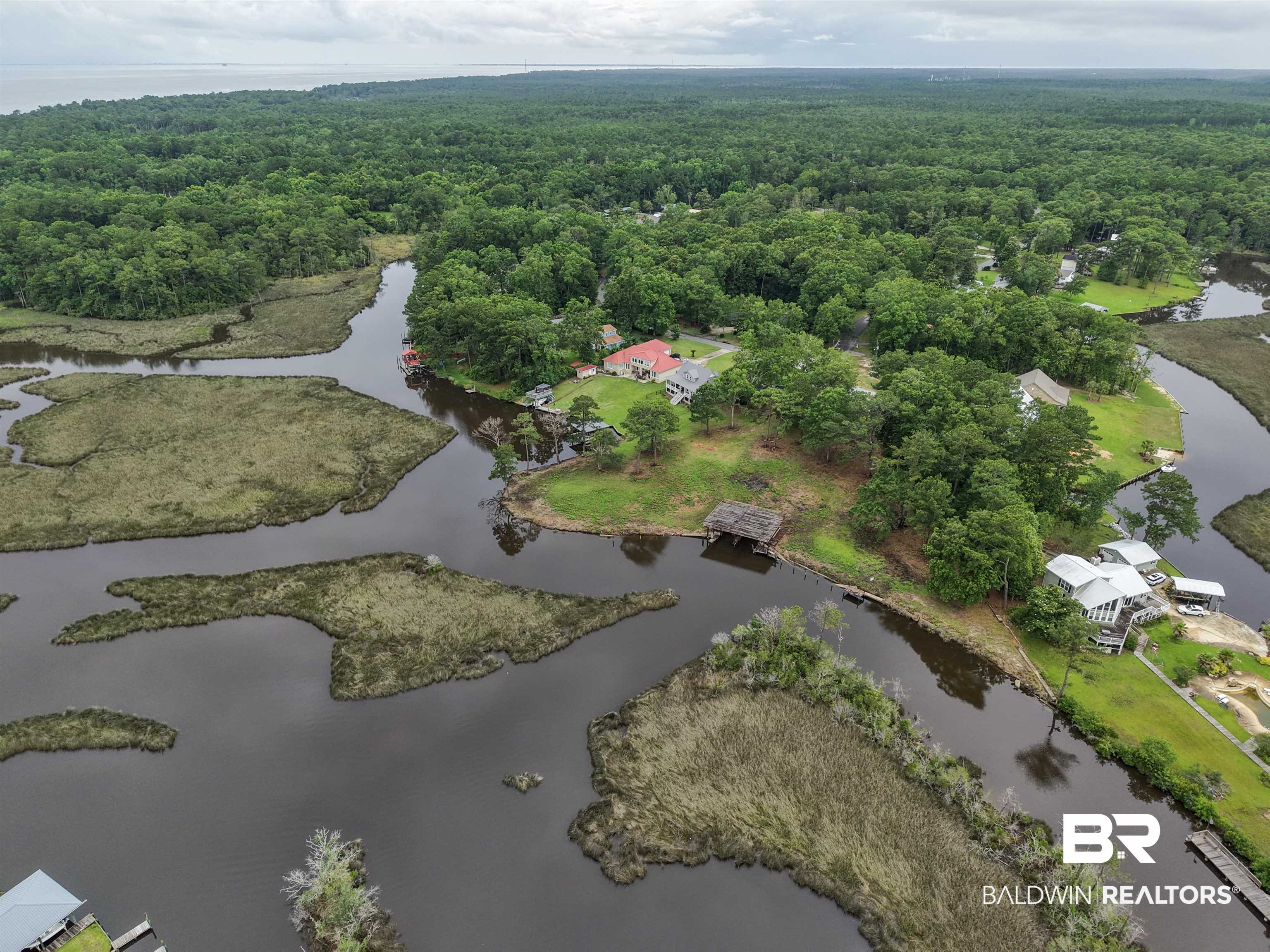12171 Marguerite Drive Coden, AL 36523 - Photo 32 of 44 Waterfront property featuring a private boat dock, surrounded by mature trees and natural marshland