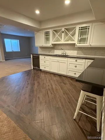 a view of kitchen with wooden floor and cabinets