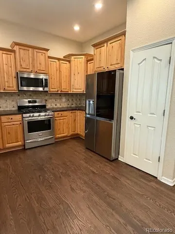 a kitchen with stainless steel appliances granite countertop a refrigerator microwave and sink