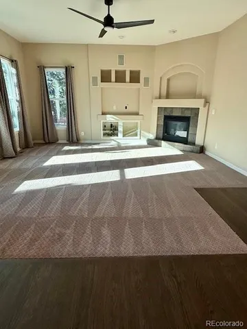 a living room with granite countertop furniture a fireplace and a flat screen tv