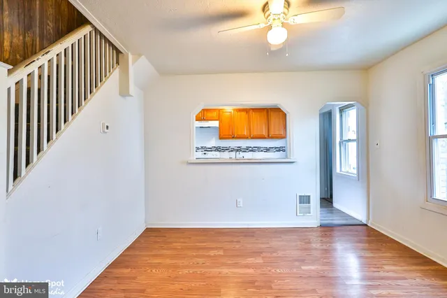 a view of a hallway with wooden floor and chandelier