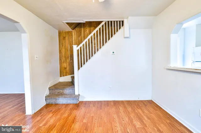 a view of a hallway with wooden floor and staircase