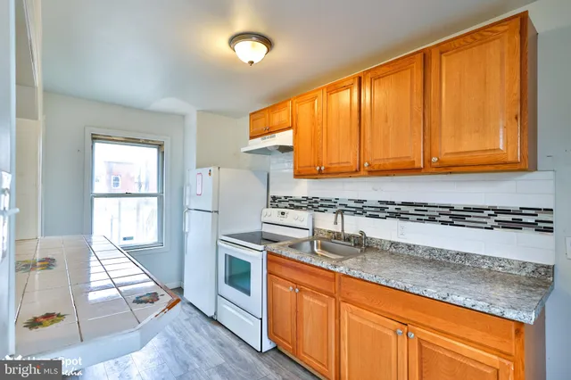 a kitchen with stainless steel appliances granite countertop wooden cabinets a sink and a window