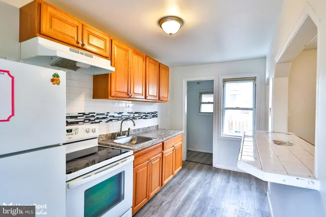 a kitchen with stainless steel appliances granite countertop a sink stove and wooden cabinets