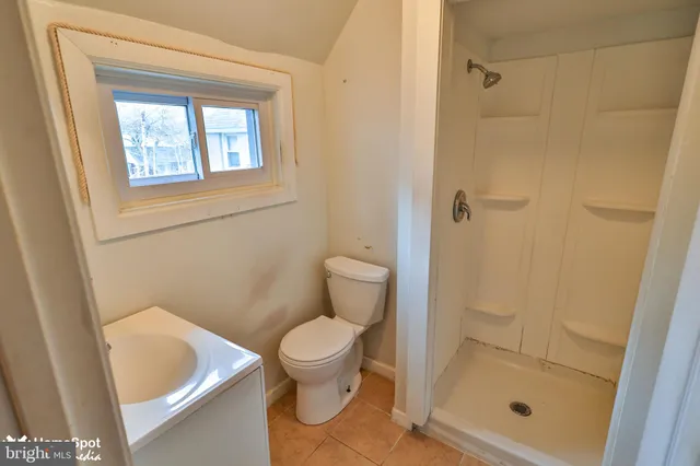 a white toilet sitting next to a shower