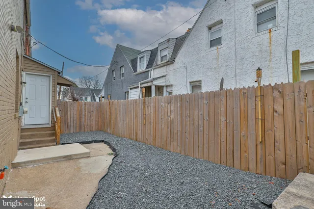 a view of a house with a wooden fence
