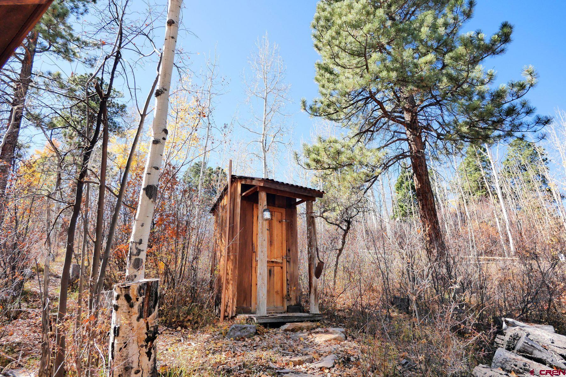 178 Valley View Road Ridgway, CO 81432 - Photo 38 of 45 a view of a wooden house with a tree and a yard