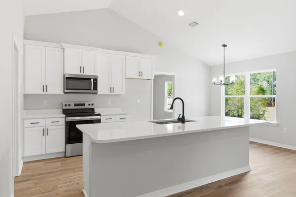a kitchen with a sink stove and microwave