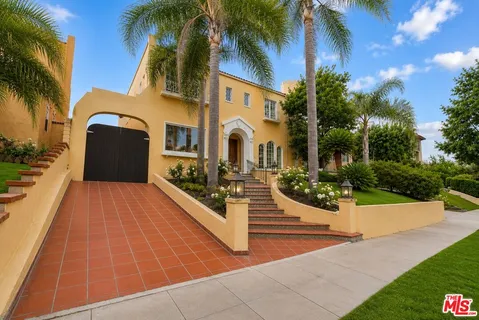 a view of a white building with a yard