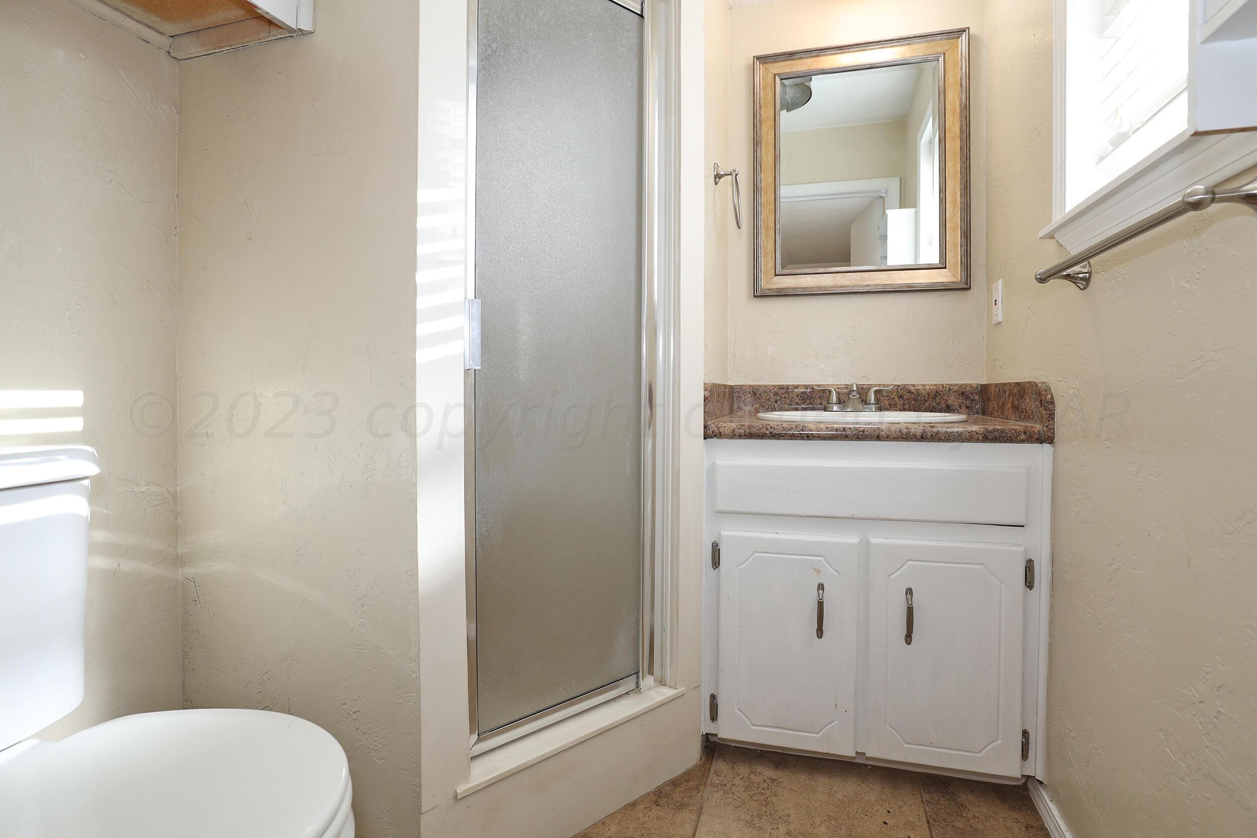 2905 Salem Drive Amarillo, TX 79110 - Photo 19 of 29 a bathroom with a toilet a sink and a mirror