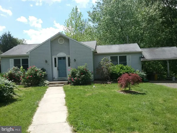 a front view of a house with a garden and plants