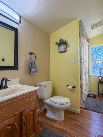 a bathroom with a sink mirror toilet and next to a window