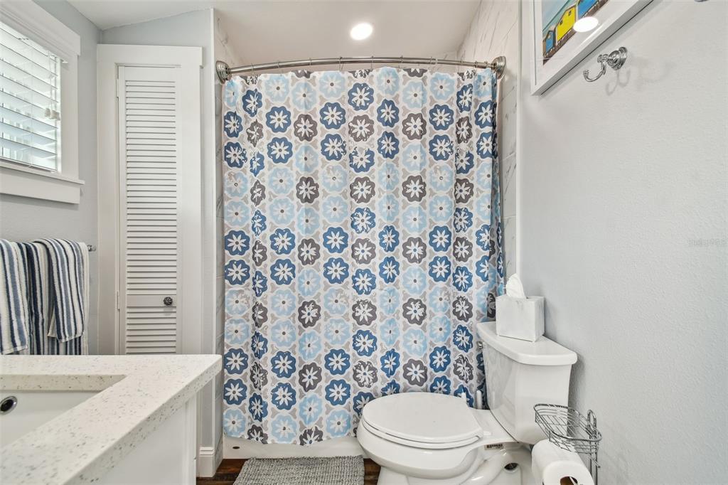 602 Skinner Boulevard Dunedin, FL 34698 - Photo 19 of 27 a white toilet sitting next to a shower curtain