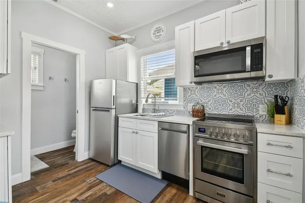 a kitchen with stainless steel appliances a stove microwave and refrigerator